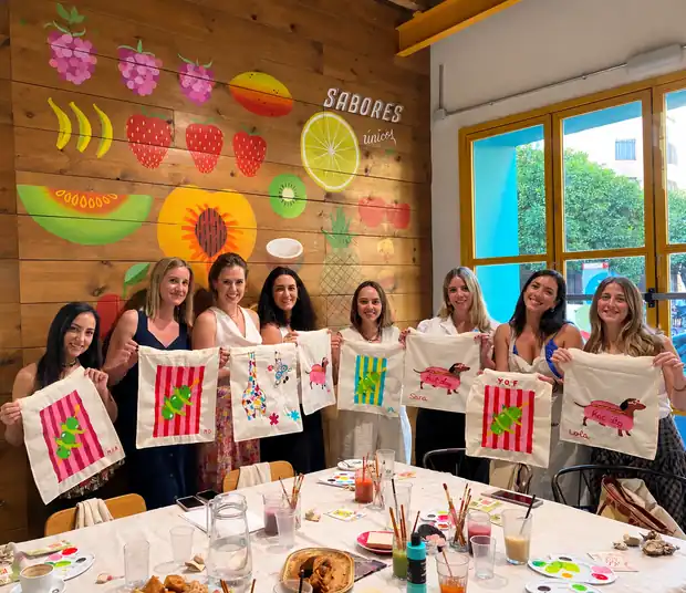 Grupo mostrando sus tote bags pintadas en una sesión privada
