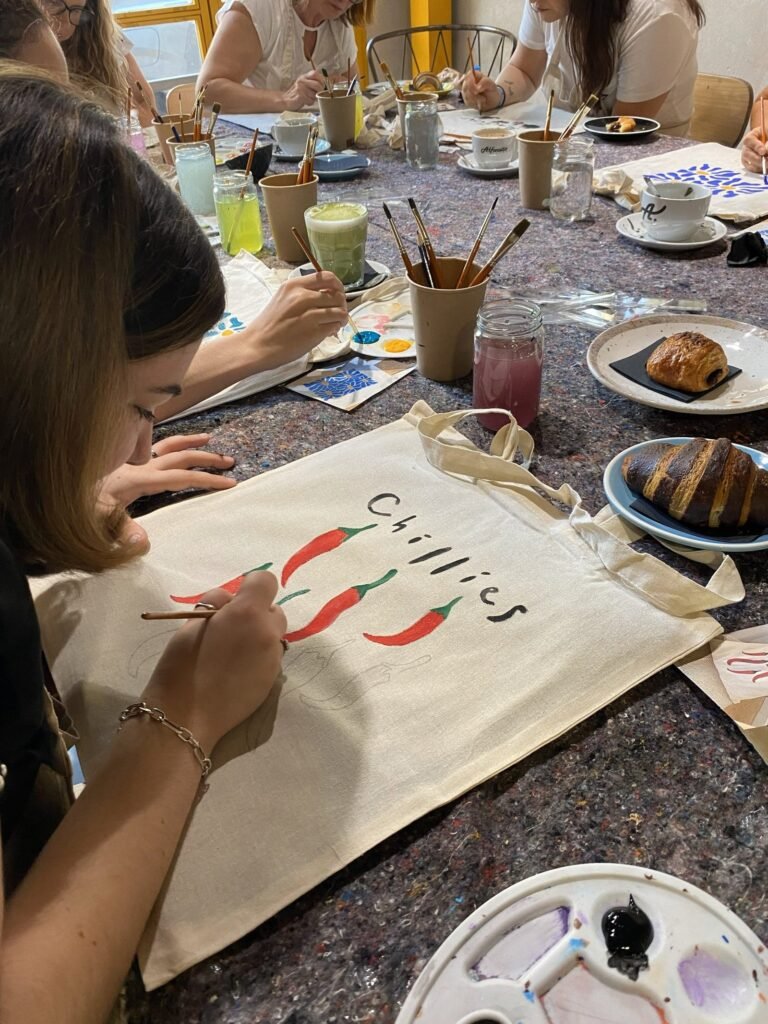 Participante pintando una tote bag