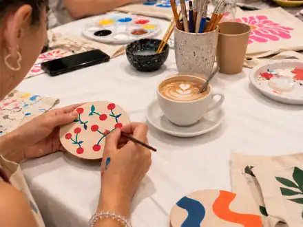 Posavasos pintado con cerezas junto a un café